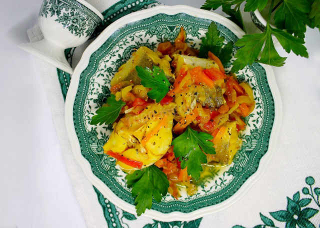 Хек тушёный с луком, морковью и овощами на сковороде