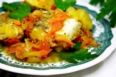 Хек тушёный с луком, морковью и овощами на сковороде